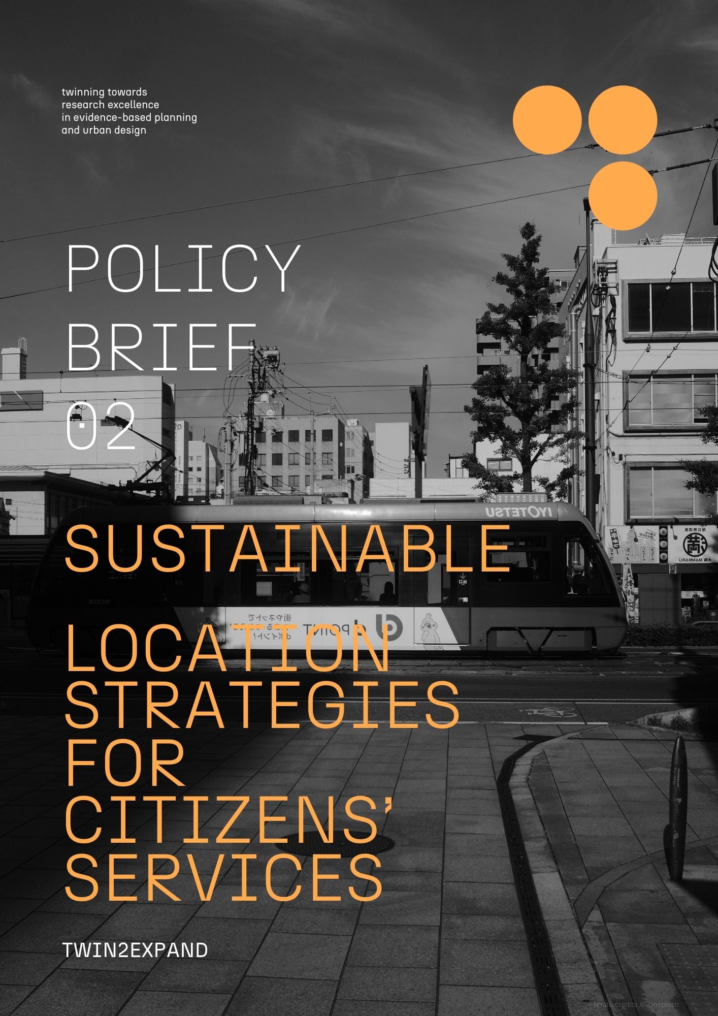 Policy Brief 2 Cover Page. Urban scene with tram passing by at junction on a street lined with a cycle lane.